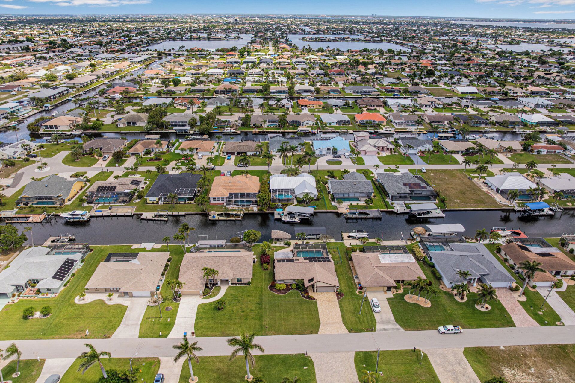 Vue aérienne d’un quartier résidentiel avec des maisons, des rues et un port de plaisance.