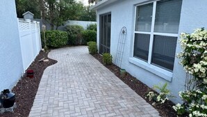 A paved pathway leading to a house with a window and a door. - 2 bdr/2 bth Courtyard Villa in The Villages w/ Cart Lake Sumter Spanish Springs (The Villages)