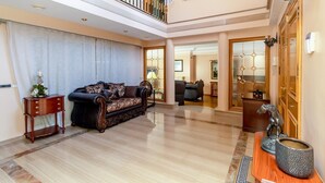 A spacious living area with a high ceiling, a staircase, and a dining area.