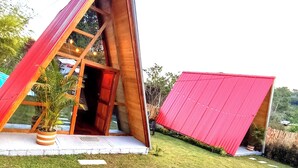 A modern house with a unique triangular roof structure and a red exterior. - Cabañas Alpina  (San Agustin)