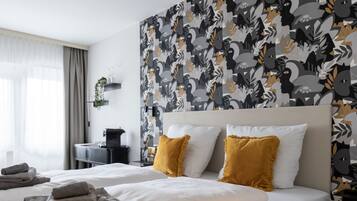 Une chambre d’hôtel avec un lit, deux oreillers, une table de chevet, une lampe et une fenêtre avec des rideaux.