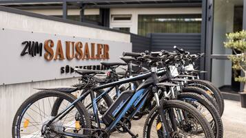 Una hilera de bicicletas estacionadas frente a un edificio con un letrero que dice "Zum SAUSALER".