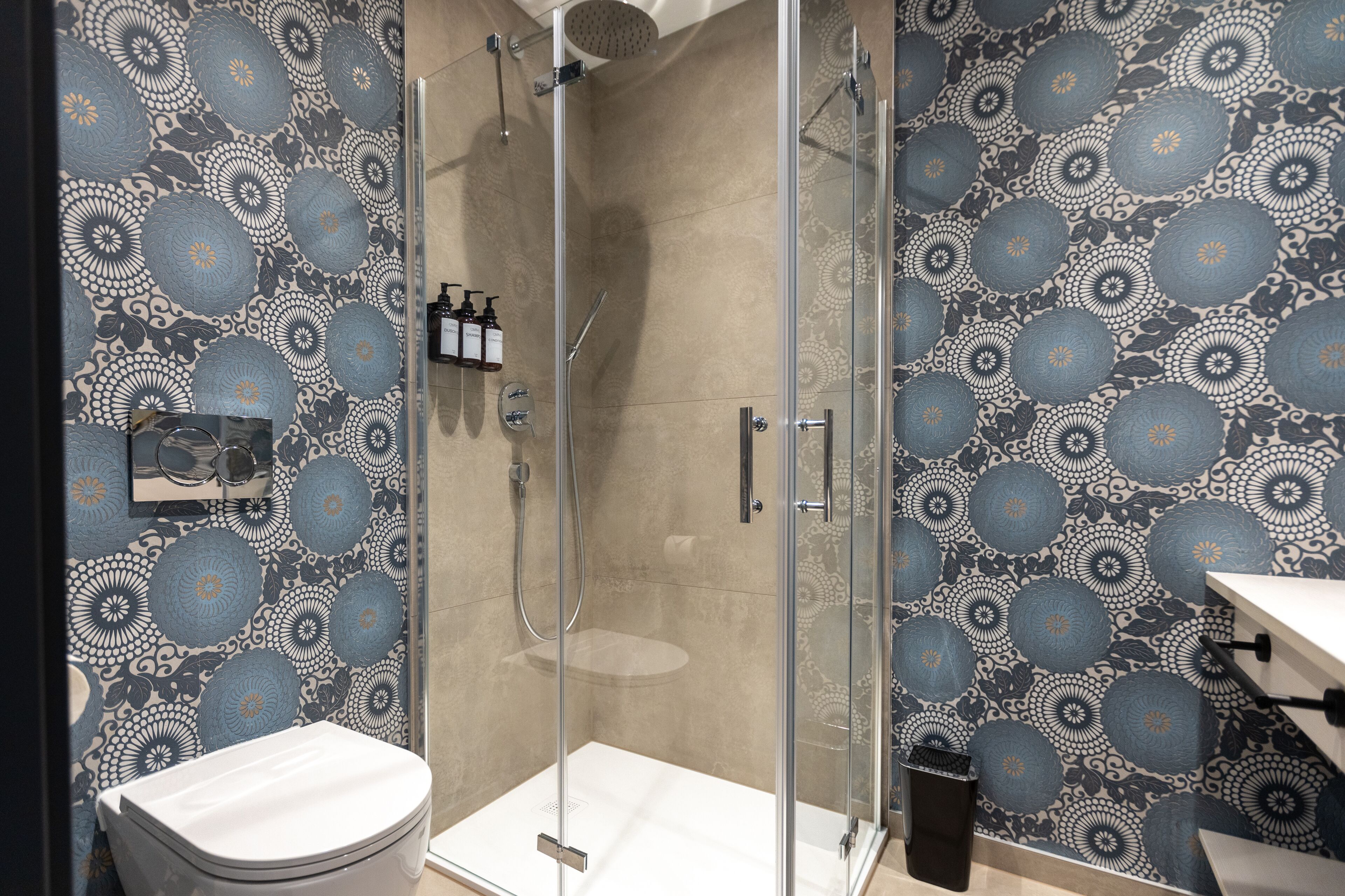 A modern bathroom with a shower enclosure, a toilet, and a sink.