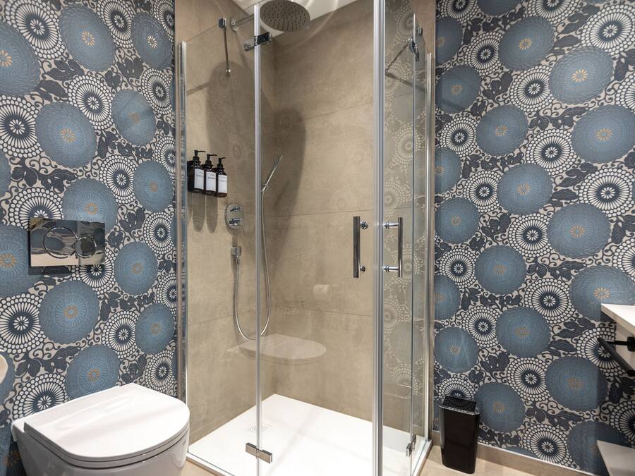 A modern bathroom with a shower enclosure, a toilet, and a sink.