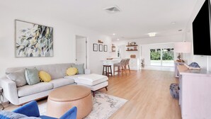 Een moderne woonkamer met een grijze bank, een salontafel en een groot abstract schilderij.