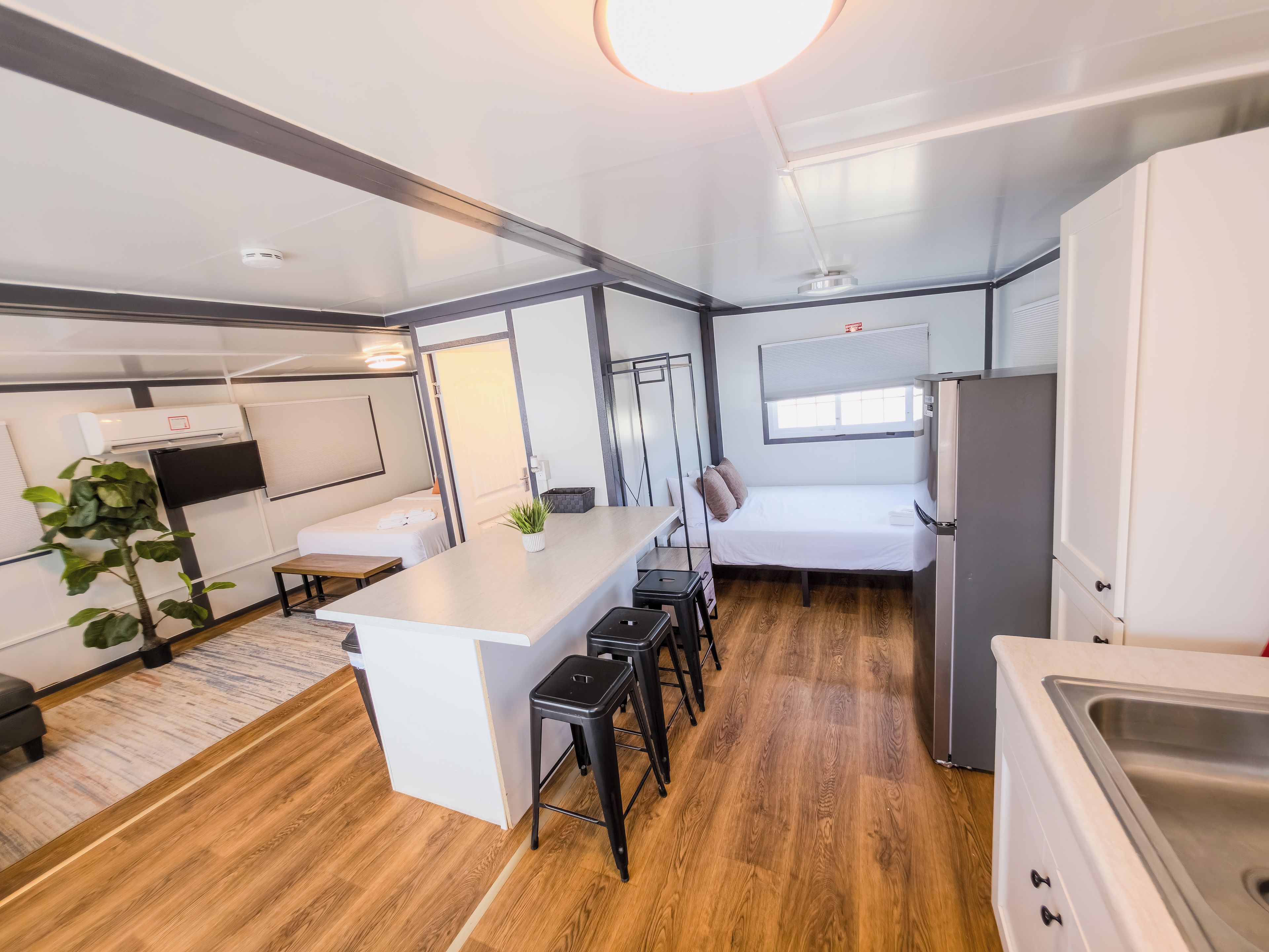 A compact kitchenette with a sink, a small countertop, and a refrigerator.