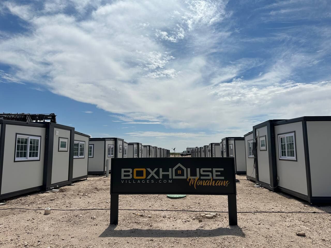 A row of BoxHouse Monahans modular homes with a sign in front.