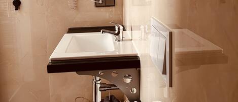 A modern bathroom with a sink, mirror, and towel rack.
