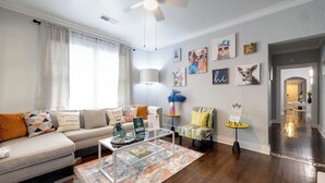 A modern living room with a sofa, coffee table, and artwork on the walls. - Midtown Tiger Retreat with ShellCrestCorp" 745 (Memphis)