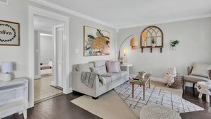 Een moderne woonkamer met een bank, salontafel en decoratieve objecten.
