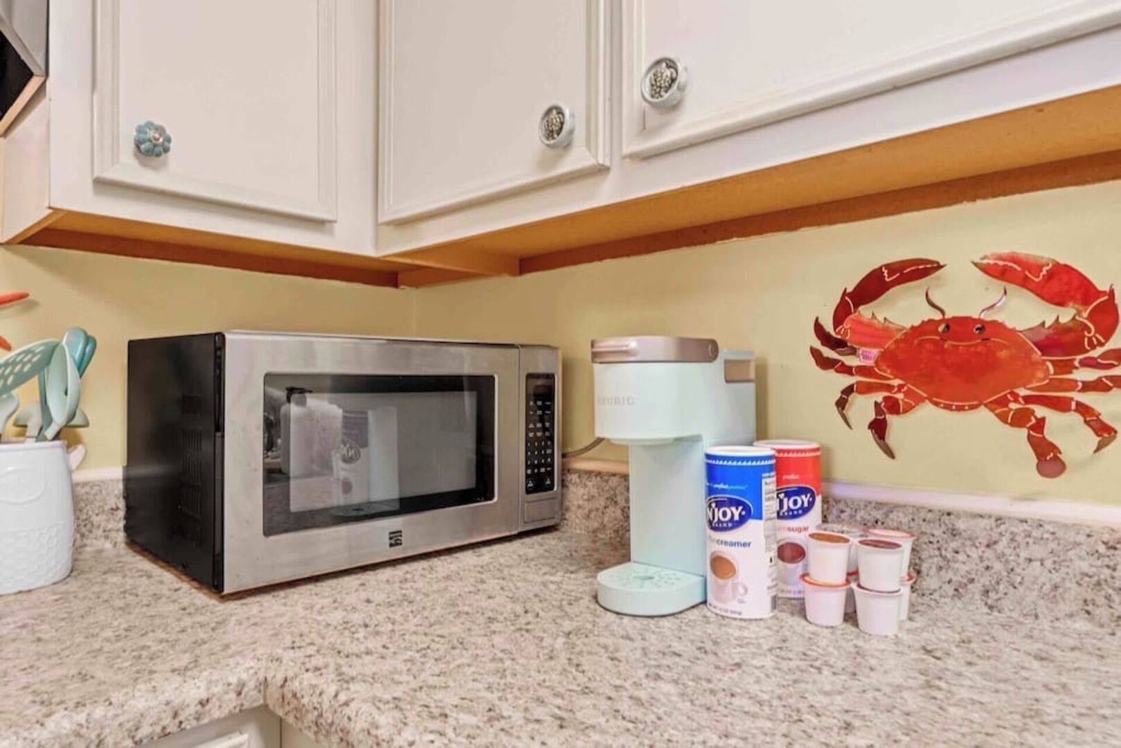 A kitchen with a microwave, a coffee maker, and various kitchen items on the counter.