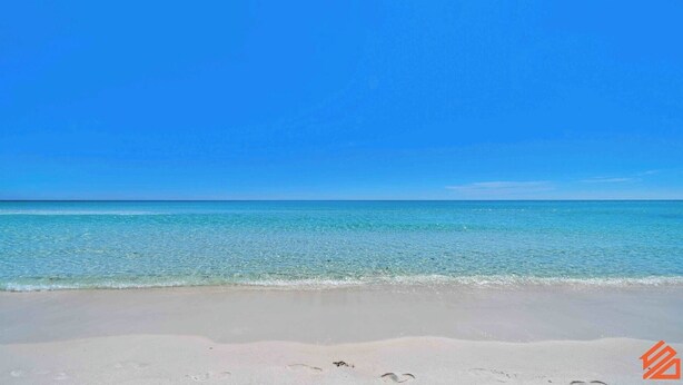 Una playa con agua turquesa cristalina y una orilla arenosa.