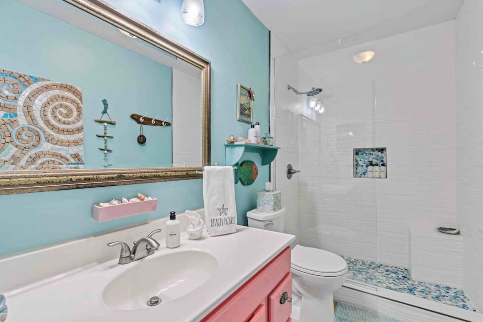 Un baño con lavamanos, espejo y ducha.