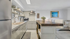 A modern kitchen with stainless steel appliances, a built-in microwave, and a wooden island.