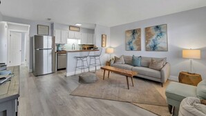 A modern apartment with a kitchen, living room, and dining area. - Okaloosa Island White Sand Beach 1BR Condo Getaway (Fort Walton Beach)