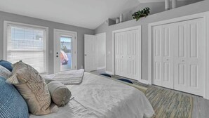 A bedroom with a bed, a ceiling fan, and a view of the outside through a door. - Large 3BR Family Destin Beach House w Beach Access (Destin)