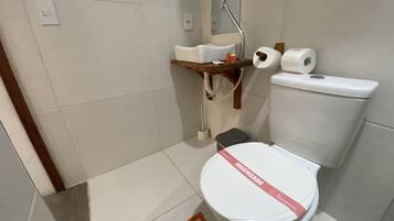 Une salle de bain moderne avec des toilettes blanches, un lavabo et un miroir.