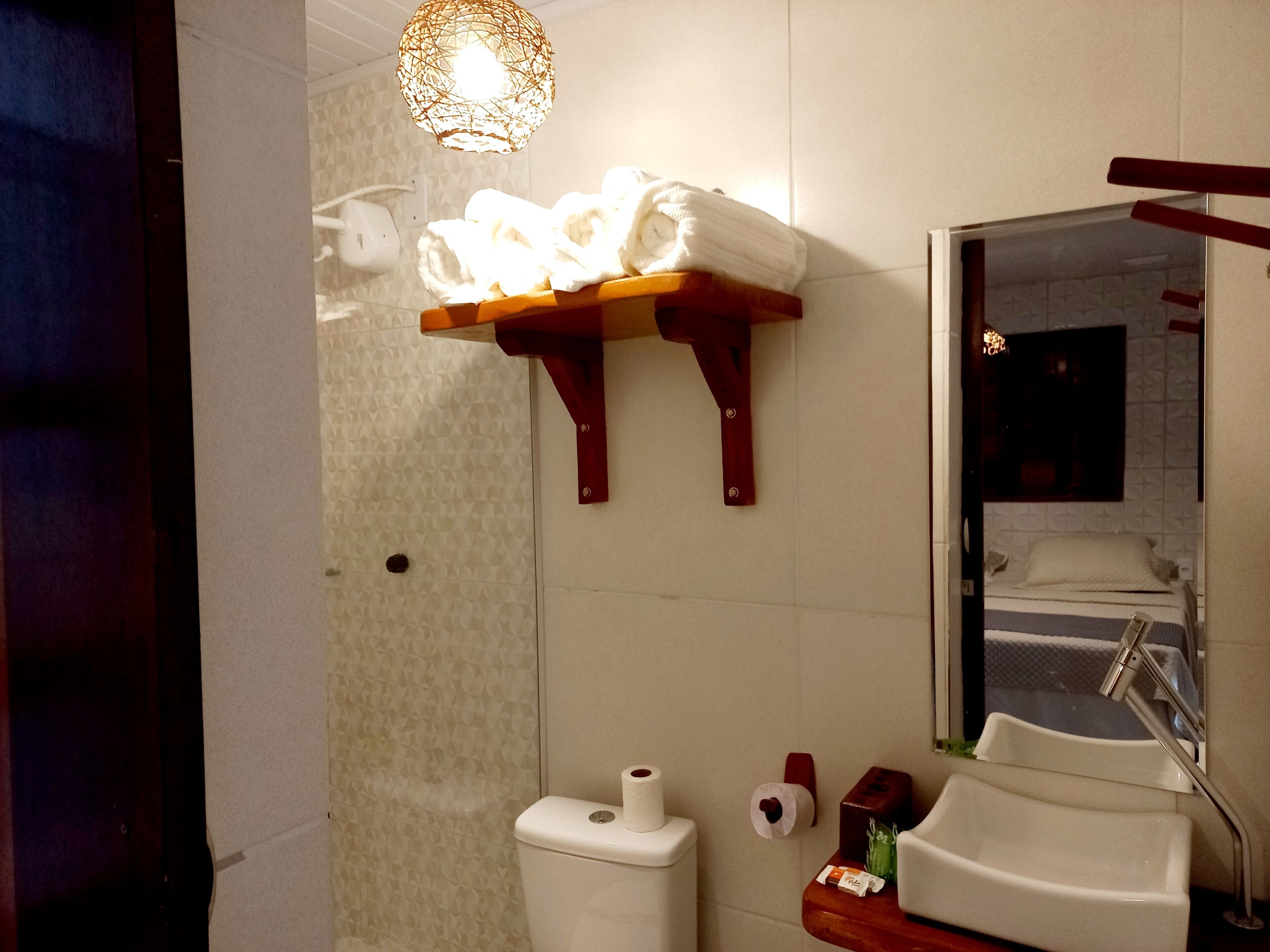 Un baño con inodoro, lavamanos y perchero para toallas.