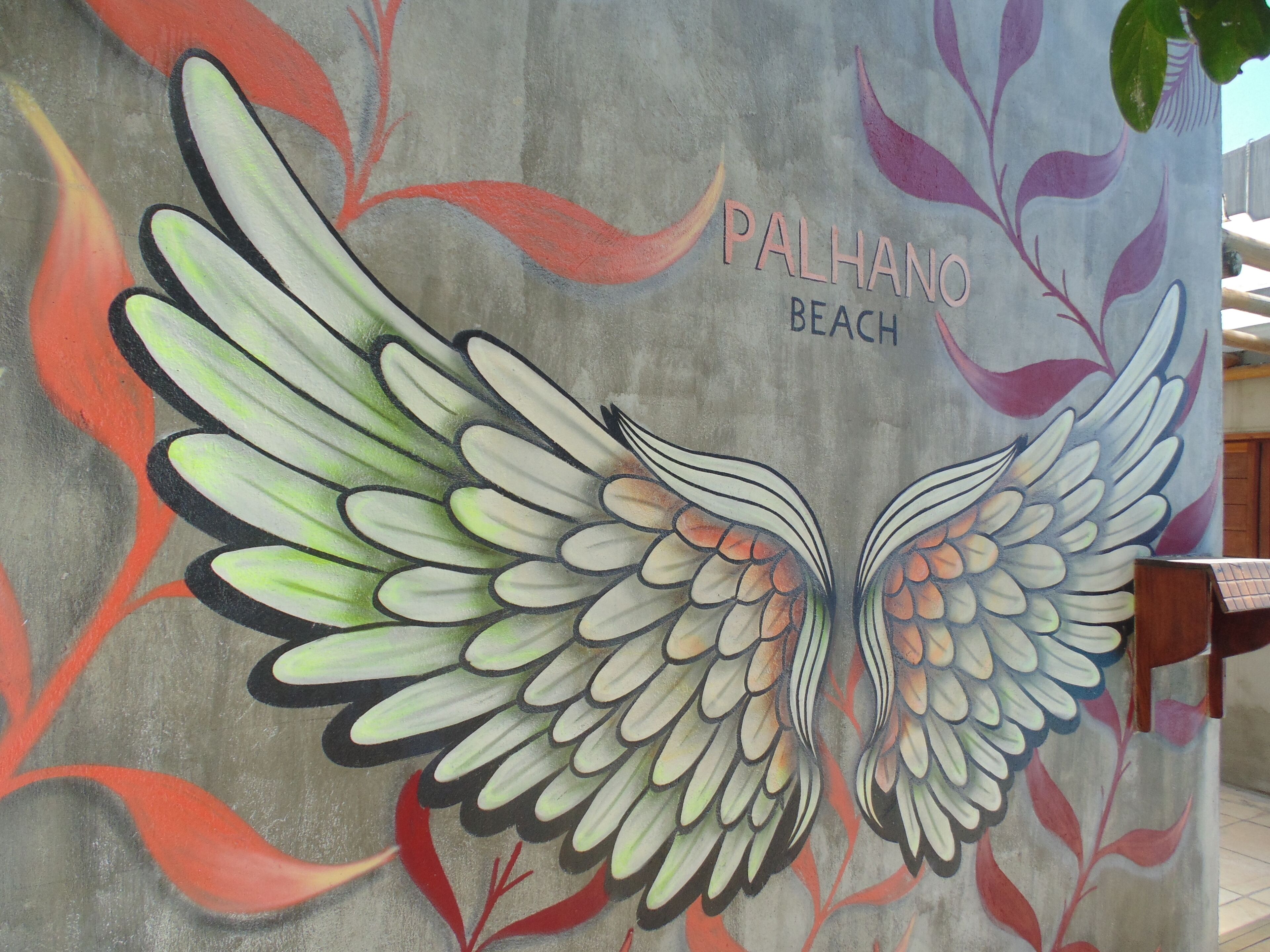 A mural of a stylized bird with outstretched wings on a wall.