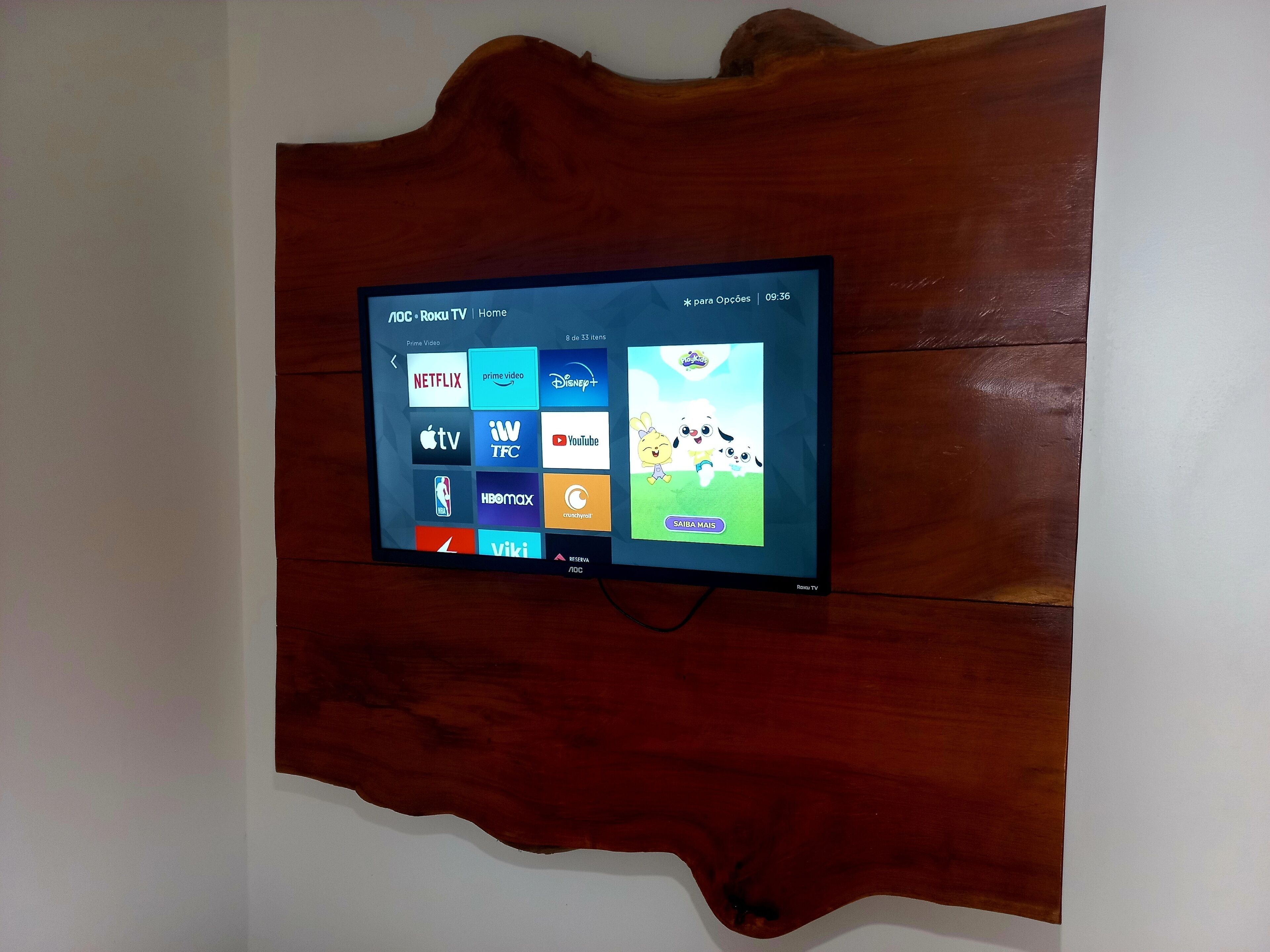Un televisor de pantalla plana montado en una pared de madera, con el logo de Netflix visible.