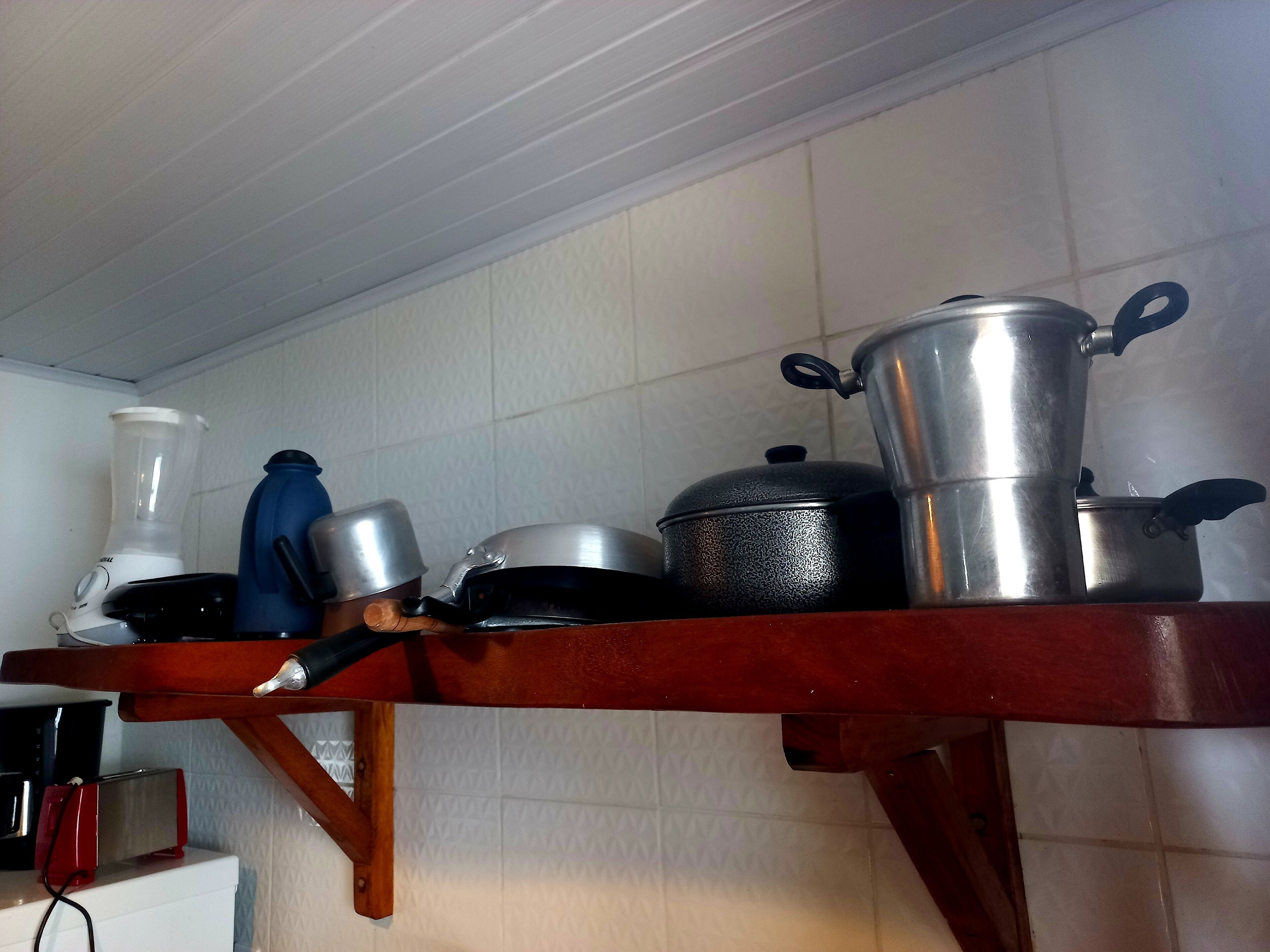 A kitchen counter with various kitchen appliances and cookware.