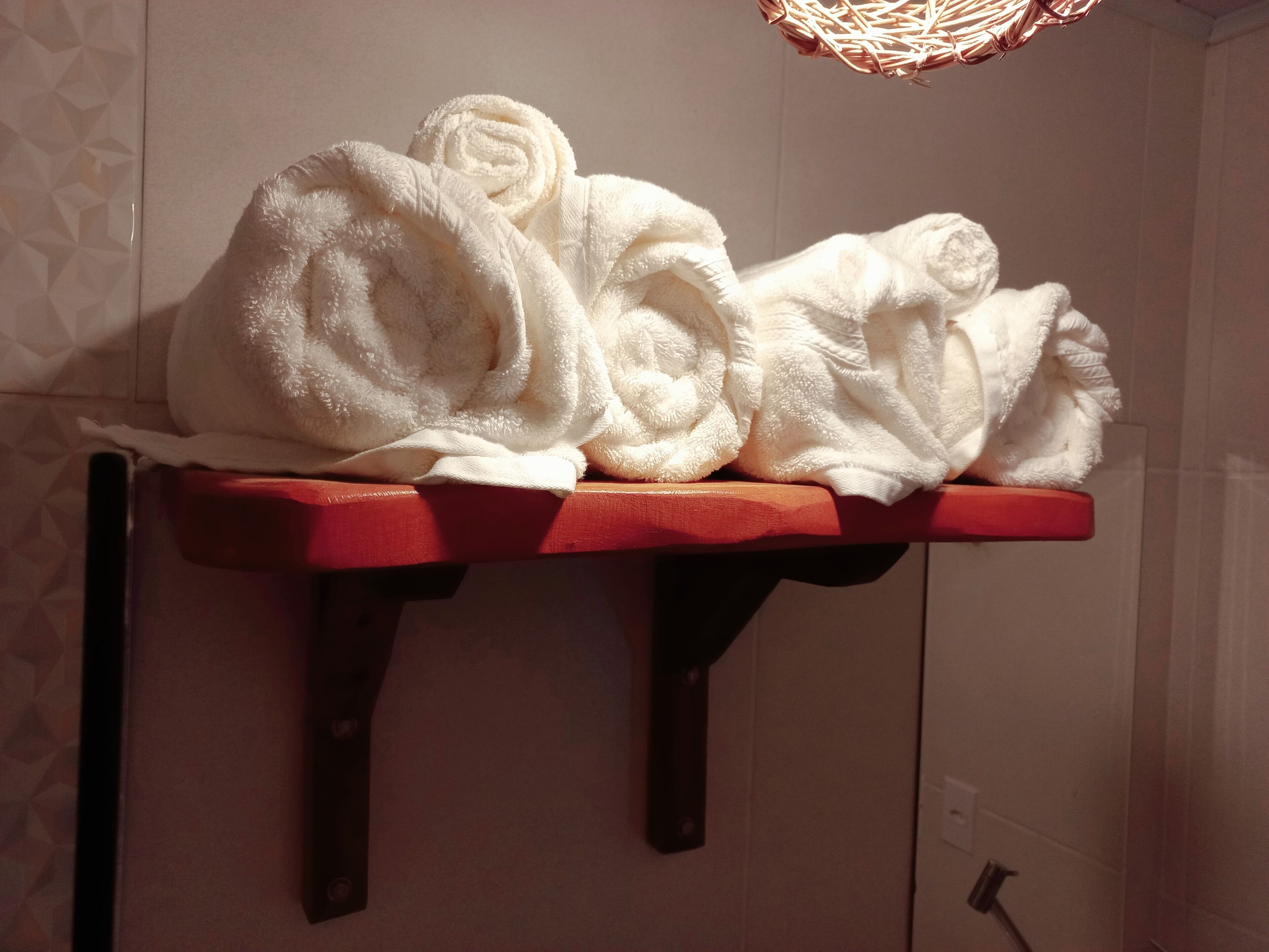 A towel rack with two rolled towels in a bathroom.