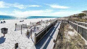 A beach with a wooden boardwalk, sandy beach, and ocean view.