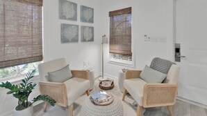 A modern living room with two beige sofas, a round coffee table, and a potted plant.