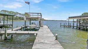 A wooden pier leading to a dock with a boat moored at the end.