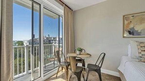 Un balcón con vistas a edificios y una mesa con sillas.