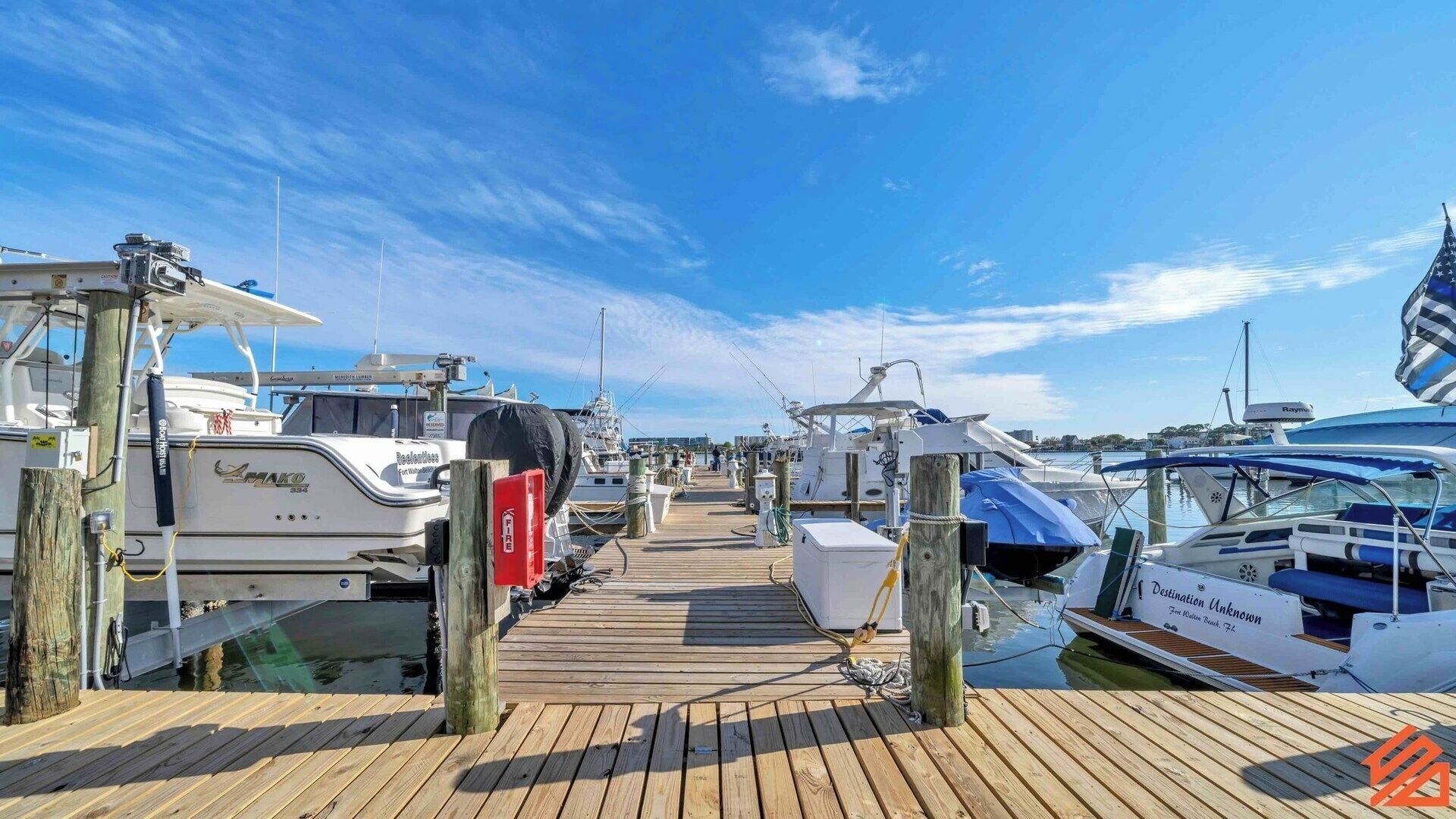 A marina with boats docked along a wooden pier.