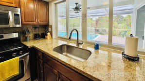Una cocina con encimeras de granito, electrodomésticos de acero inoxidable y armarios de madera.