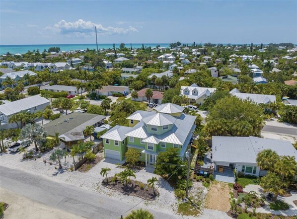 A coastal residential area with houses, some with metal roofs, surrounded by greenery and palm trees. - Villa Rozafa
Cozy,spacious,walking distance from downtown white sandy beach. (Anna Maria)