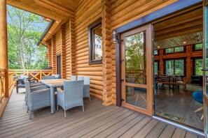 Enjoy cooking and dining outdoors with a grill and spacious table. - Log House Vacation Rental with Pool and Sauna (Pocono Township)