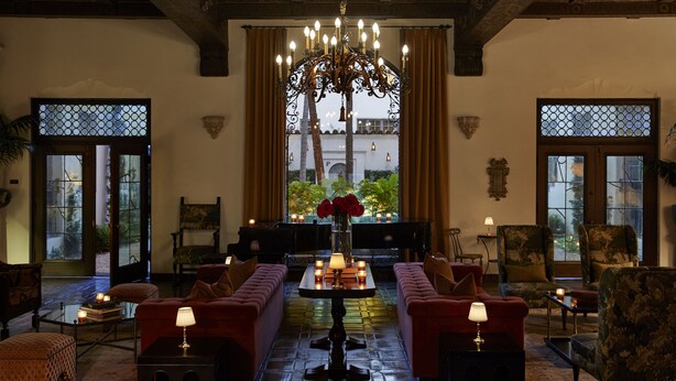 Un salon confortable avec un grand lustre, des fauteuils moelleux et une vue par la fenêtre.