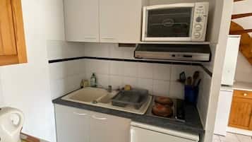 Een koelkast, kookgerei, borden en bestek