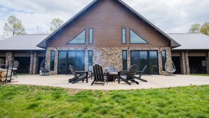 A modern house with a stone facade, large windows, and outdoor seating. - Possum Pocket Lodge
 (Nortonville)