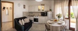 A compact living space with a kitchenette, a dining area, and a sofa.