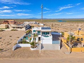 A modern resort with a pool, a tall tower, and a desert landscape.