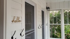 Ein heller Raum mit Fenster, Tür und einem an der Wand befestigten Schild mit der Aufschrift 'hello'.