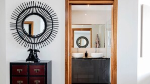 Une salle de bain moderne avec deux lavabos, un miroir et un élément décoratif mural.