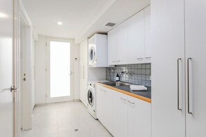 Enjoy cooking in this well-equipped kitchen with a washing machine and stainless steel sink.