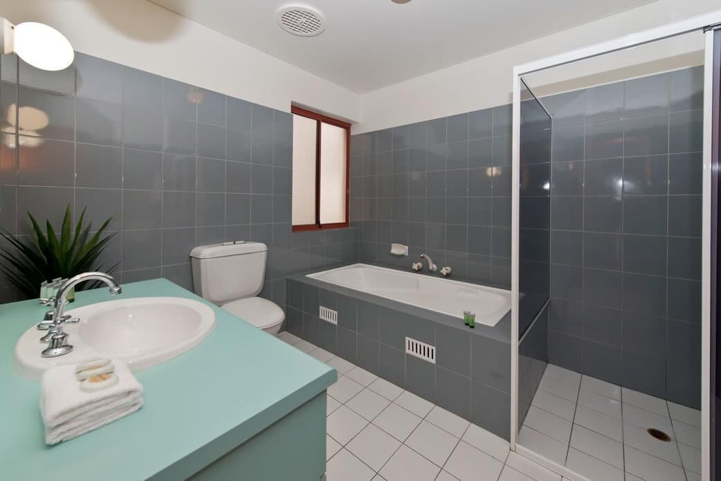 A bathroom with a sink, toilet, bathtub, and a glass shower enclosure.
