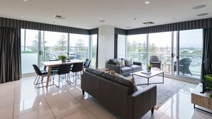 Una sala de estar moderna con sofá, mesa de centro y comedor.