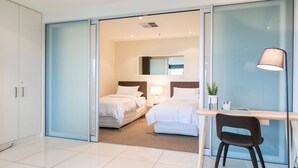 Una habitación de hotel moderna con una cama grande, un escritorio y una silla.