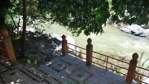 Een betonnen trap leidt naar een balustrade met uitzicht op een rivier.