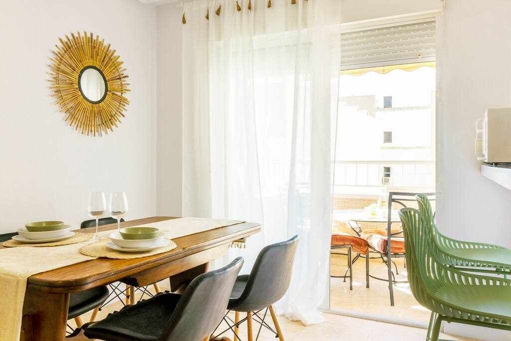 Uma área de refeições com uma mesa de madeira, cadeiras e uma cadeira verde.