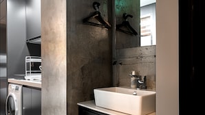 Un bagno moderno con uno specchio grande, un lavandino e una lavatrice.