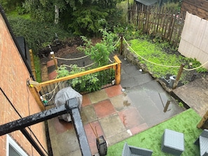 Ein Garten mit einem Holzzaun, einem Metallgeländer und verschiedenen Pflanzen.