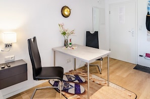 A modern room with a white table, black chair, and a vase with flowers.